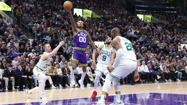 Mar 12, 2024; Salt Lake City, Utah, USA; Utah Jazz guard Jordan Clarkson (00) lays the ball up between Boston Celtics forward Sam Hauser (30) and guard Derrick White (9) during the fourth quarter at Delta Center